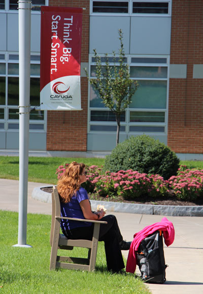 Student sitting on a bench on a summer day