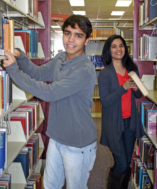 Students looking at course material in the Library